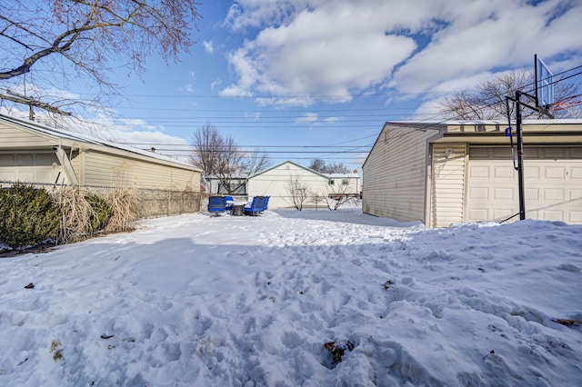 yard covered in snow featuring a garage