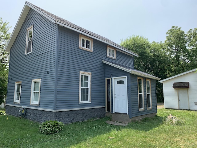 rear view of property featuring a lawn