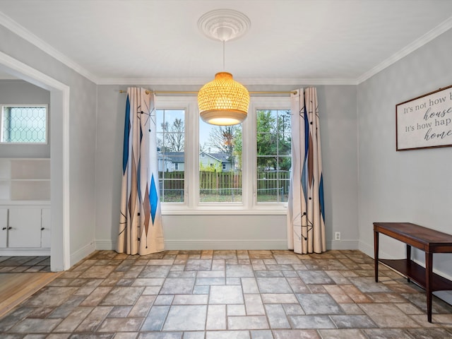 dining area with stone finish flooring, crown molding, and baseboards