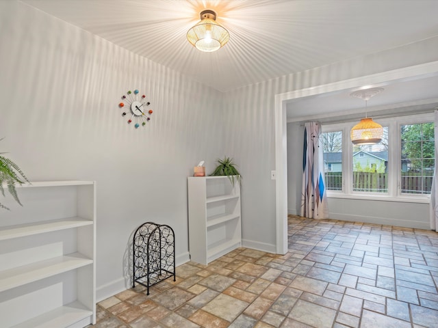 spare room with stone finish flooring and baseboards