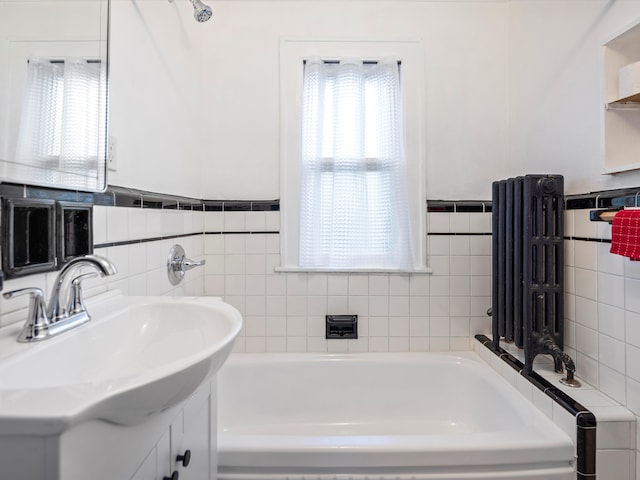 full bathroom with wainscoting, a garden tub, and vanity