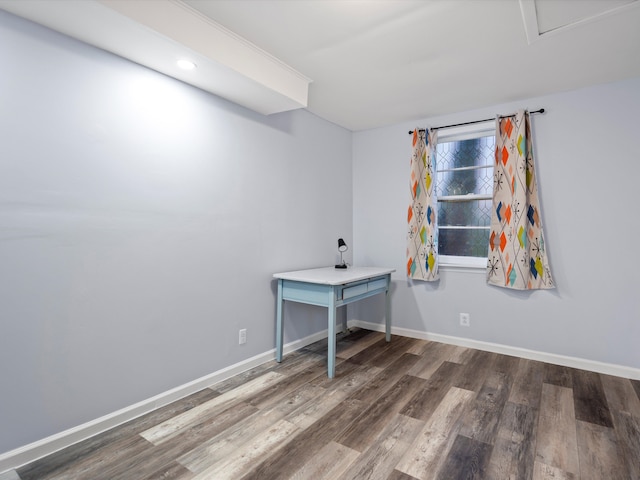 unfurnished office featuring dark wood-style flooring and baseboards