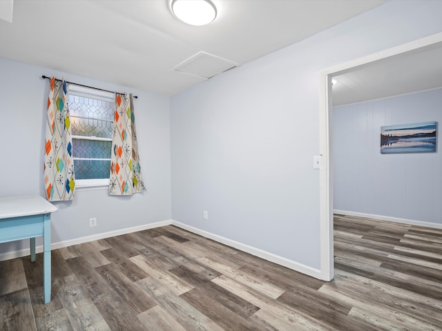 interior space with attic access, baseboards, and dark wood finished floors