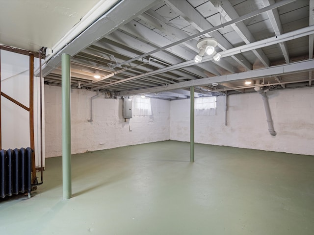 basement featuring radiator and electric panel