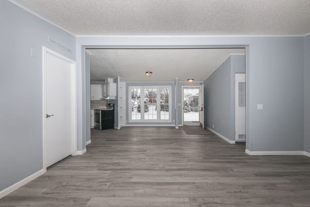 unfurnished living room featuring a textured ceiling, wood finished floors, and crown molding