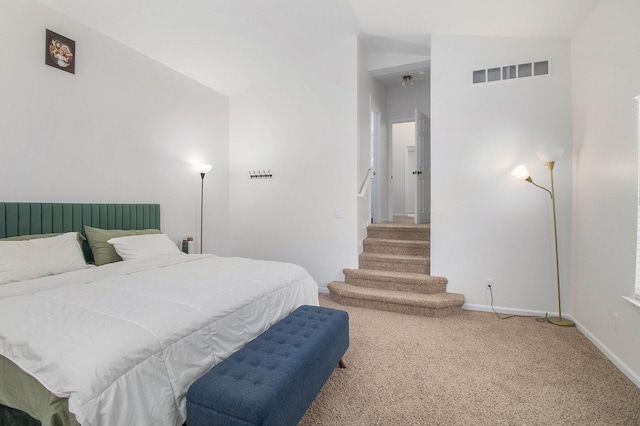 carpeted bedroom with lofted ceiling, visible vents, and baseboards