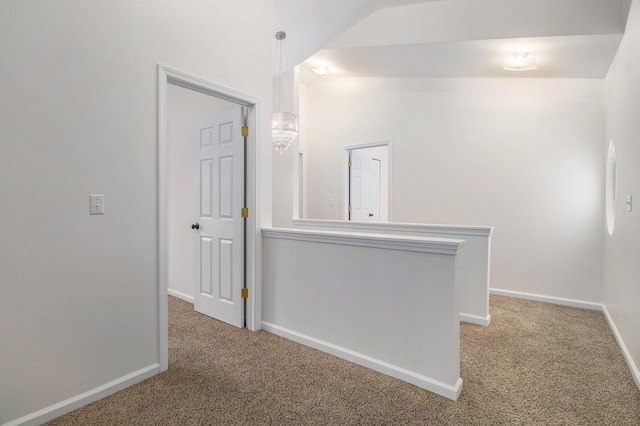 hall with lofted ceiling, carpet floors, and baseboards