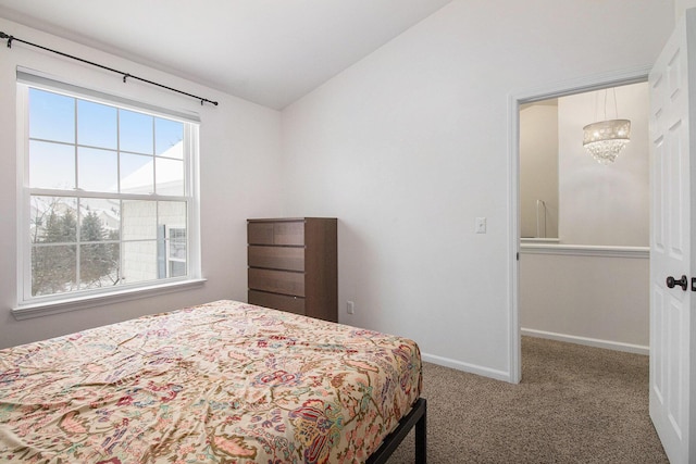 carpeted bedroom featuring lofted ceiling and baseboards