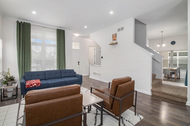 living room featuring a wealth of natural light, visible vents, and stairs