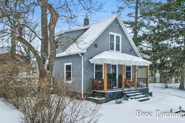 view of front of house featuring covered porch and a chimney