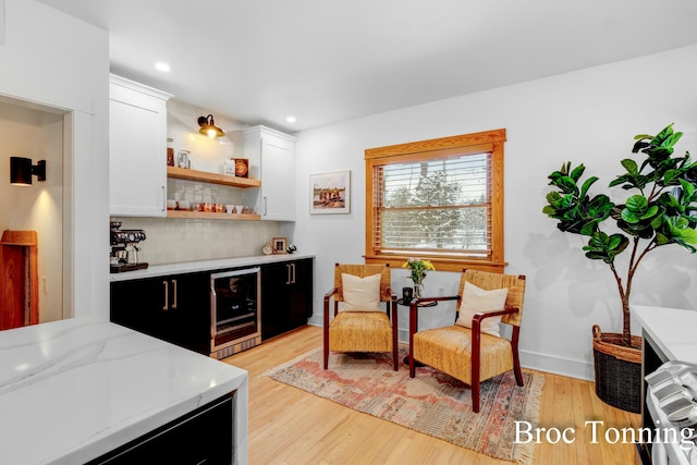 bar featuring wine cooler, recessed lighting, light wood-style floors, a dry bar, and tasteful backsplash