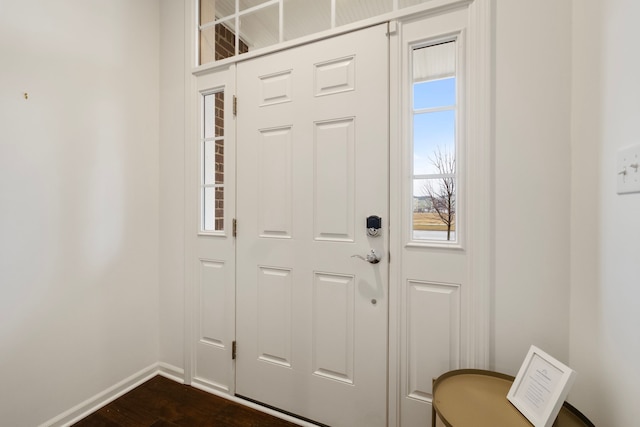 foyer featuring dark wood finished floors and baseboards