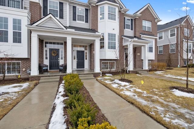 multi unit property with covered porch and brick siding