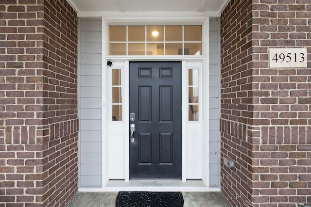 doorway to property featuring brick siding