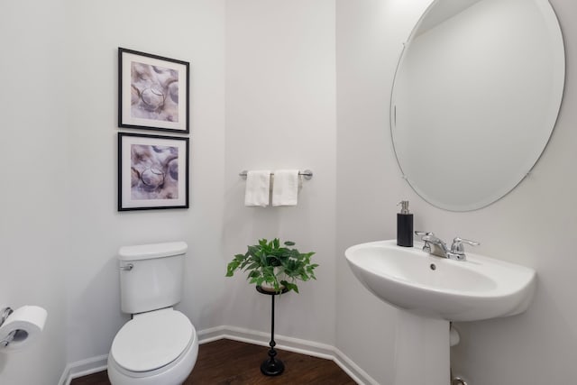 bathroom with baseboards, toilet, and wood finished floors