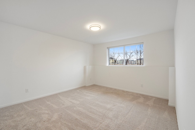 carpeted spare room featuring baseboards