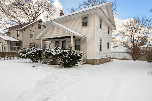 view of front of home featuring covered porch and a chimney