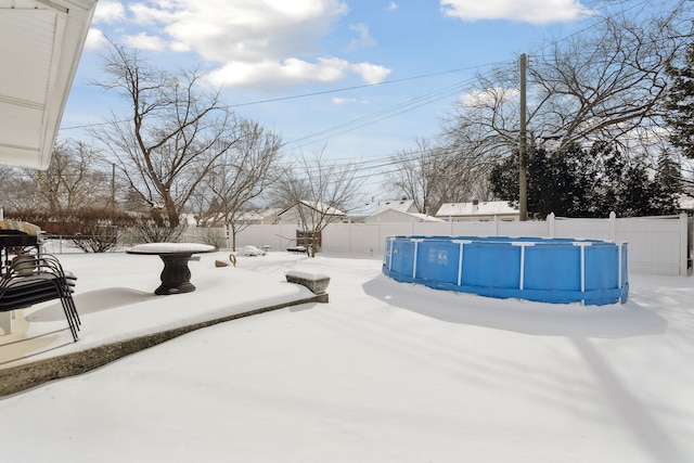 yard covered in snow featuring fence and a fenced in pool