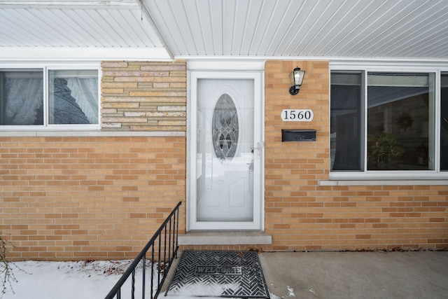 entrance to property featuring brick siding