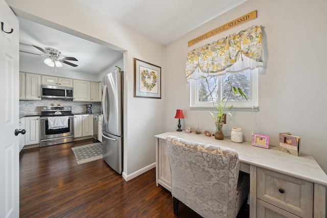 kitchen with dark wood-style floors, built in desk, decorative backsplash, appliances with stainless steel finishes, and ceiling fan