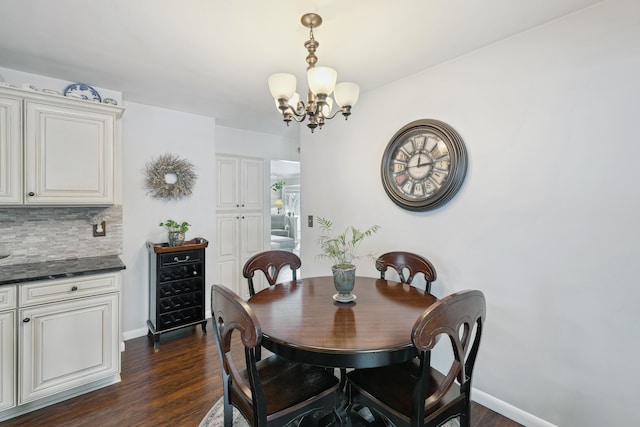 dining area with an inviting chandelier, baseboards, and dark wood finished floors