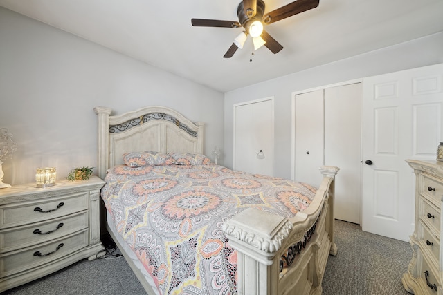 bedroom with dark carpet, two closets, and ceiling fan