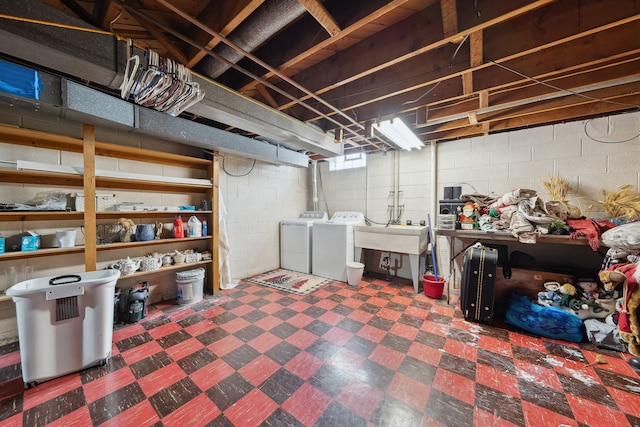 basement featuring dark floors, independent washer and dryer, and a sink