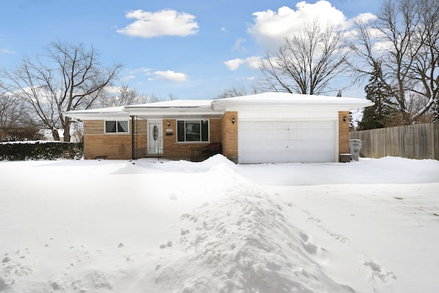 single story home with a garage, brick siding, and fence