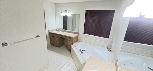 bathroom with tile patterned flooring, vanity, and a tub with jets