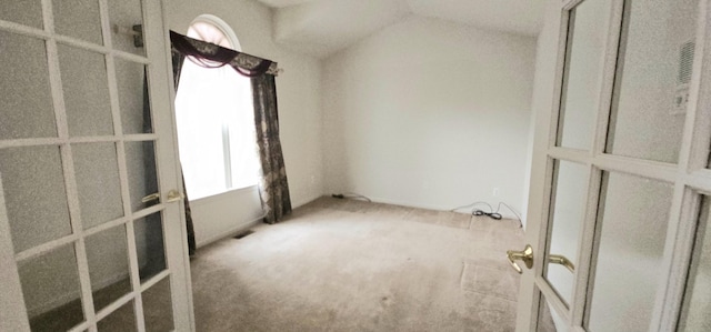 spare room featuring lofted ceiling, carpet floors, and a wealth of natural light