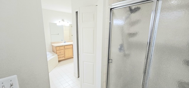 bathroom featuring a stall shower, tile patterned flooring, a bath, and vanity