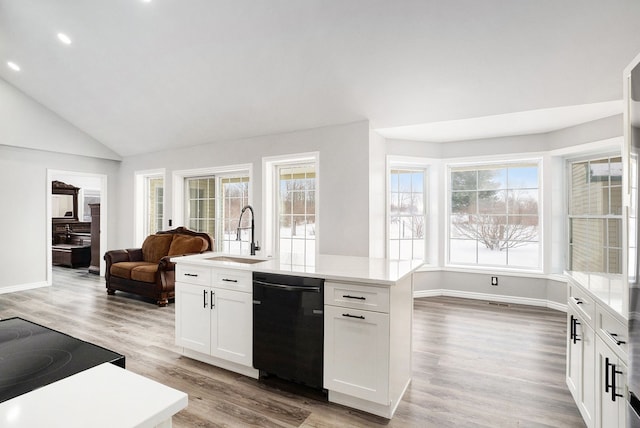 kitchen featuring dishwasher, light countertops, open floor plan, and white cabinetry