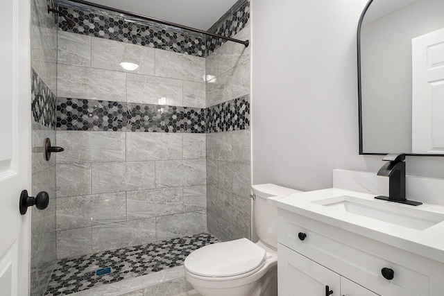 bathroom with a stall shower, vanity, and toilet