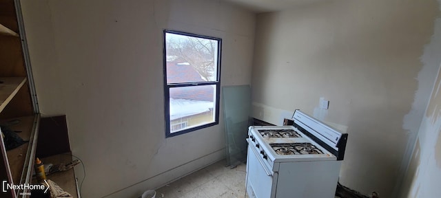 kitchen with light countertops, washer / dryer, white cabinetry, and a healthy amount of sunlight