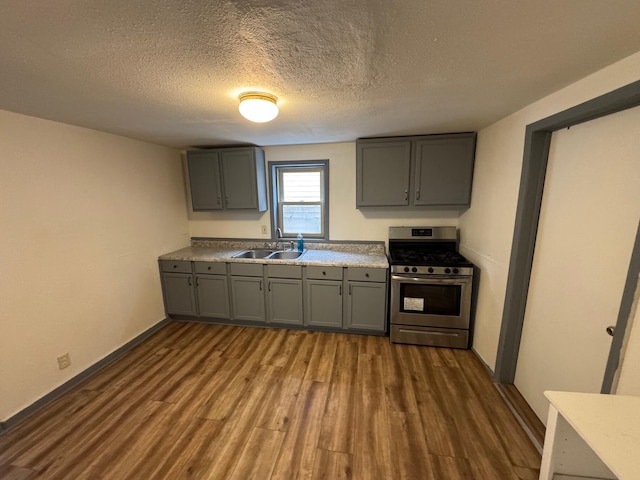 kitchen featuring a sink, stainless steel gas range oven, and gray cabinetry