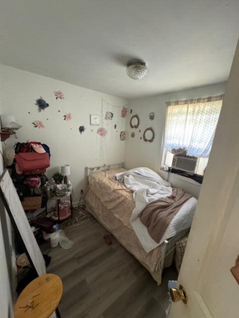 bedroom with dark wood-type flooring and cooling unit