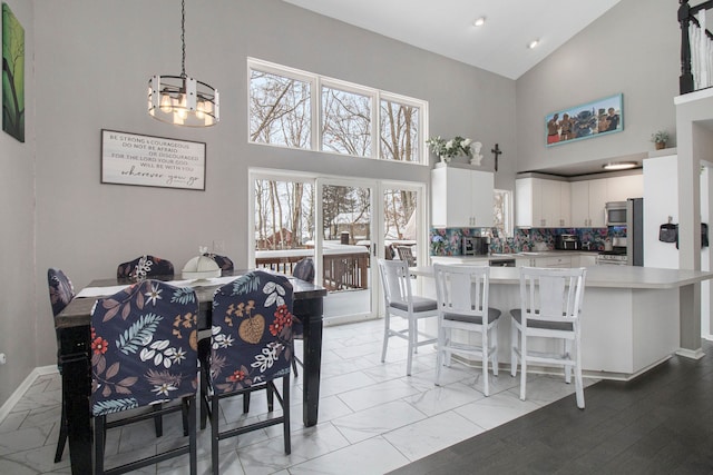 2839 Davista Dr, Highland, MI 48356 - dining area with a chandelier, high vaulted ceiling, light marble finish floors, baseboards, and recessed lighting