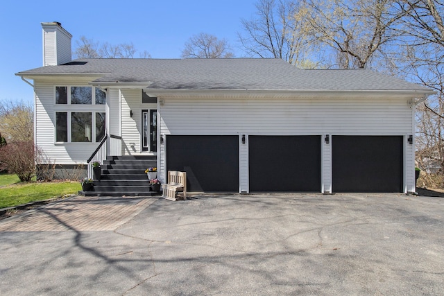 2839 Davista Dr, Highland, MI 48356 - view of front of home with a chimney, asphalt driveway, a shingled roof, and an attached garage