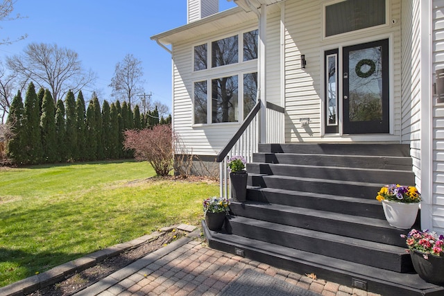 2839 Davista Dr, Highland, MI 48356 - view of exterior entry featuring a chimney and a lawn