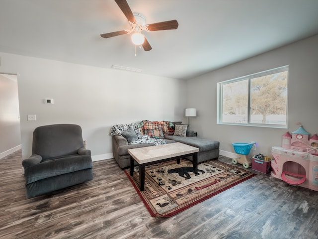 living room featuring visible vents, baseboards, ceiling fan, and wood finished floors