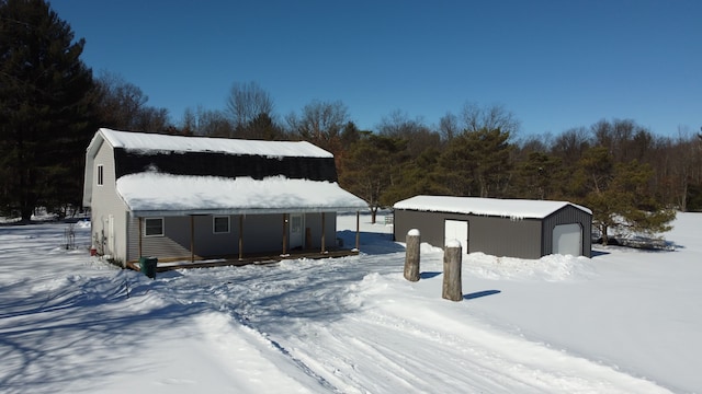 view of front of property featuring a garage, an outdoor structure, and a gambrel roof