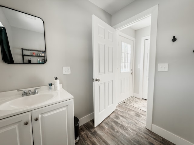 bathroom featuring wood finished floors, vanity, and baseboards