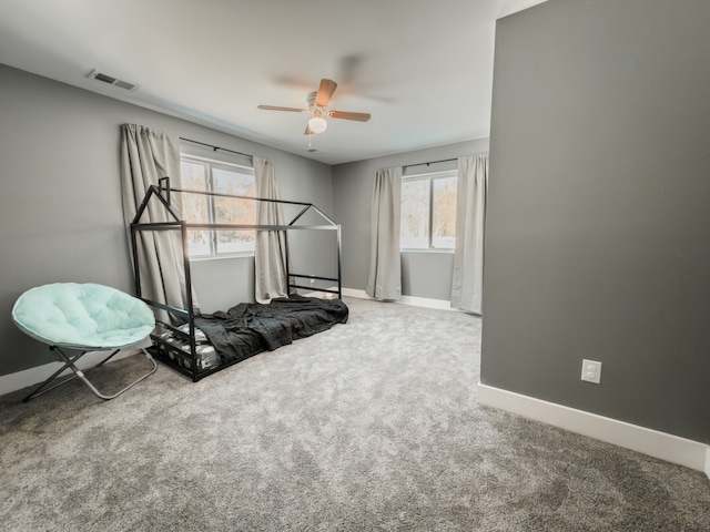 carpeted bedroom with ceiling fan, visible vents, and baseboards