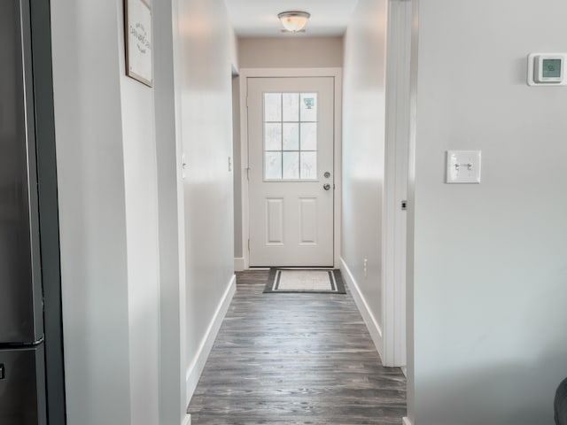 doorway to outside featuring dark wood finished floors and baseboards