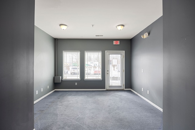 carpeted spare room featuring visible vents and baseboards