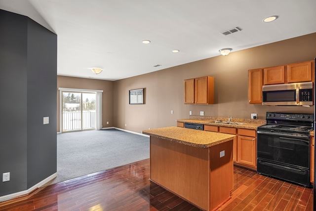 kitchen featuring a sink, visible vents, open floor plan, a center island, and black appliances