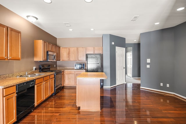 kitchen featuring light stone counters, visible vents, a sink, a kitchen island, and black appliances