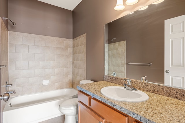 bathroom with washtub / shower combination, vanity, and toilet