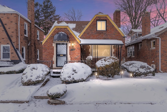 english style home featuring brick siding