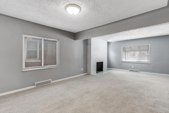 unfurnished living room featuring a brick fireplace, visible vents, and light colored carpet